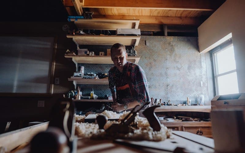 A craftsperson working with wood in a workshop
